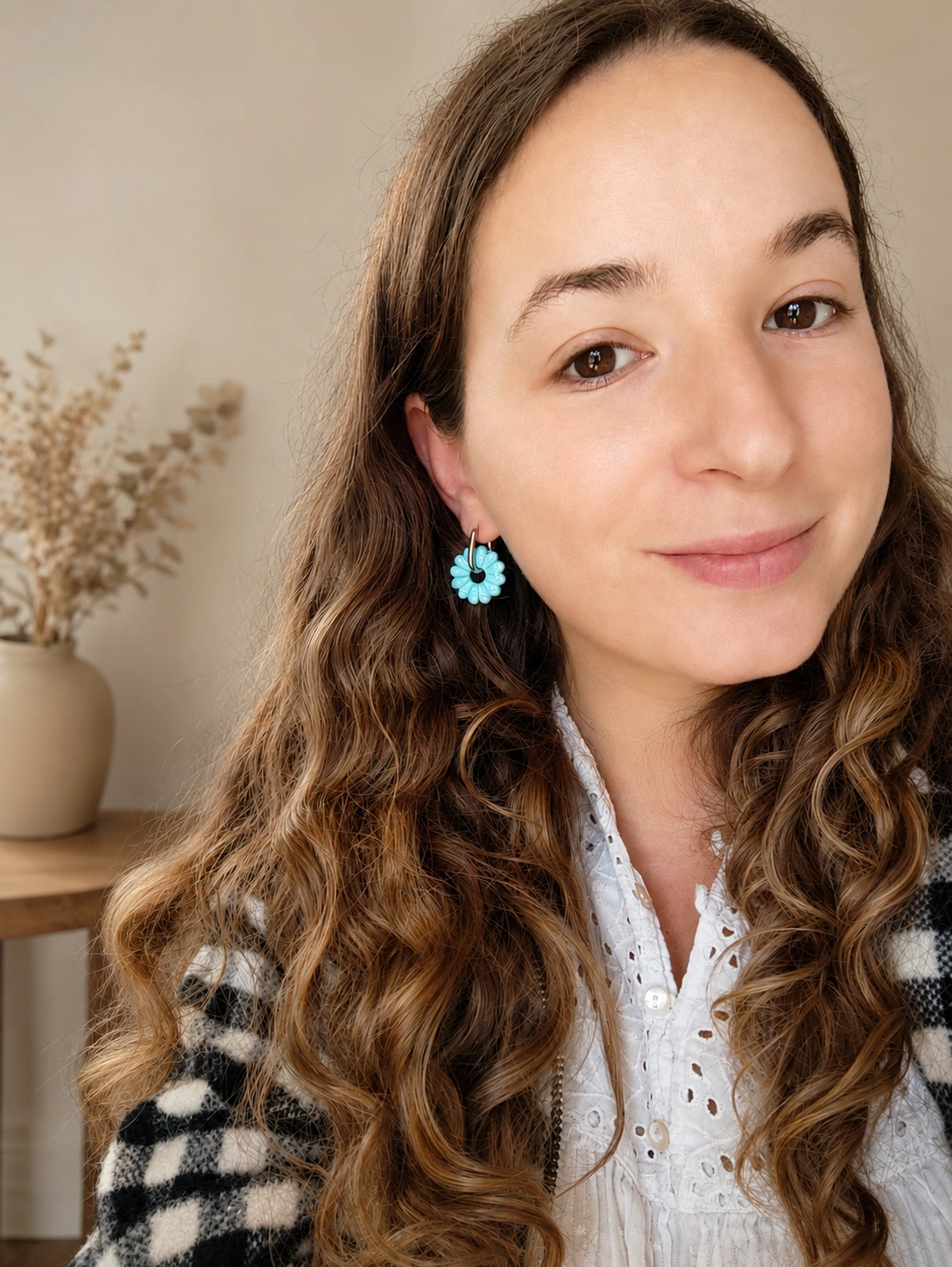 Mélinda, créatrice de Haimy Créations, portant une boucle d'oreille fleur bleue